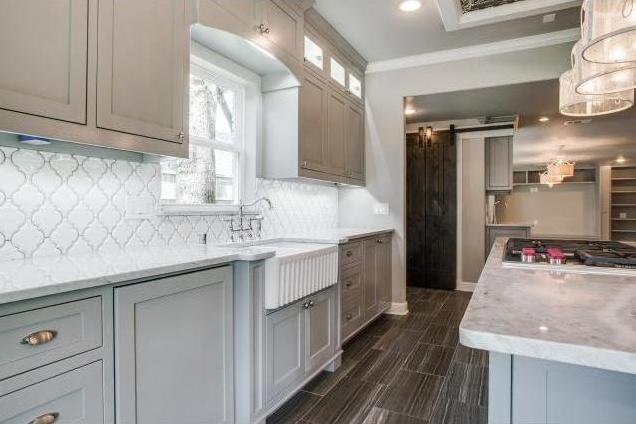 Marble counters, farm sink and beveled Arabesque porcelain back