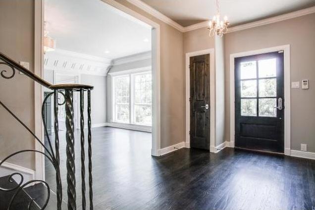 Entry with original oak floors and vintage wrought-iron stair ra