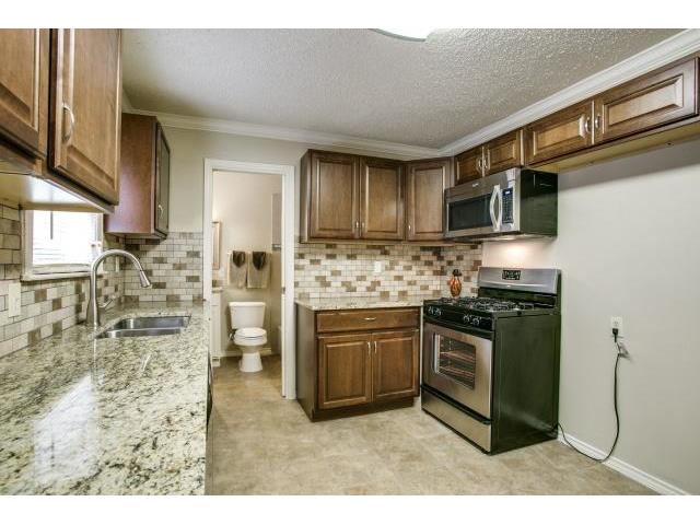 It Also Features A Stone Backsplash, Granite Countertops, And Ne