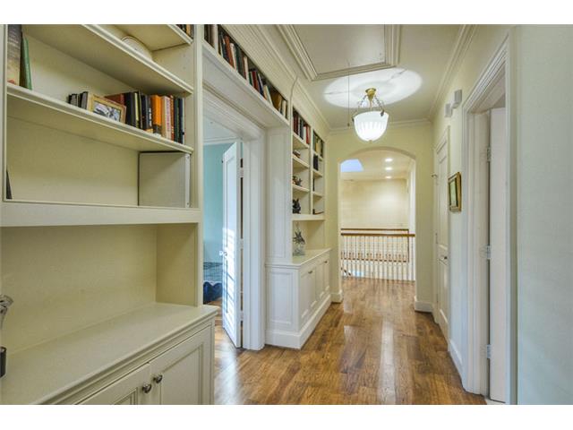 The wide second floor hallway furnished with built-in bookshelve