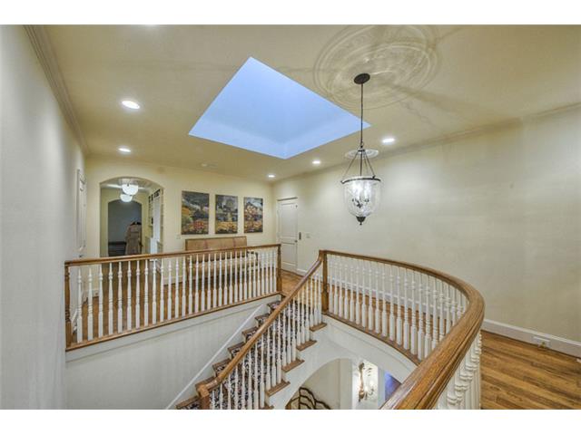 The graceful curving stairway leads to the second level where al