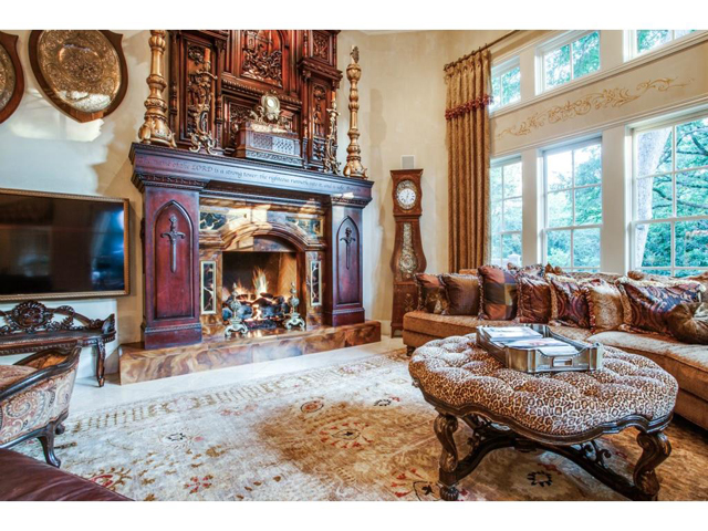 Great room also features a towering imported antique mantle over
