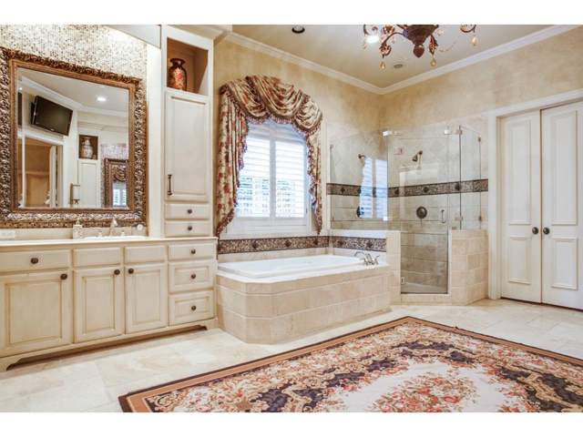 Updated master bath offers travertine floors, separate shower wi
