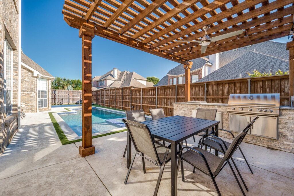 backyard pool with trellis over outdoor kitchen